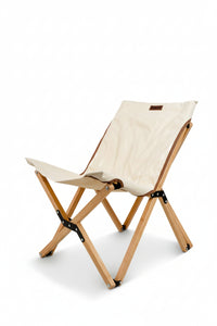 Foldable chair with white seat and wooden frame on a beige background