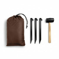 Brown drawstring bag, three black tent stakes, and a wooden mallet on a beige background